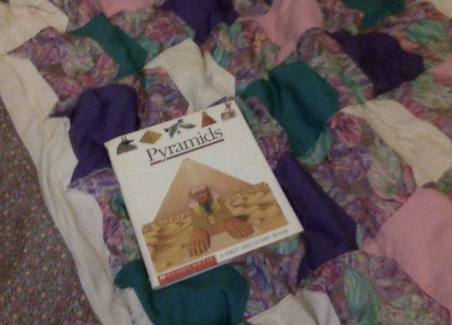 Image of old 'Pyramids' book laying on a quilt